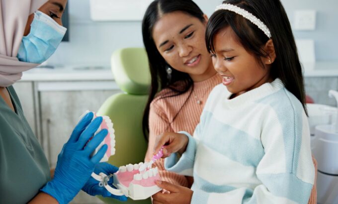 Child, pediatric dentist or teach on brushing teeth in practice or kid friendly demonstration of to.
